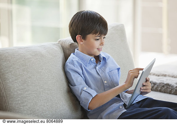 Junge mit Tablet-Computer auf dem Sofa