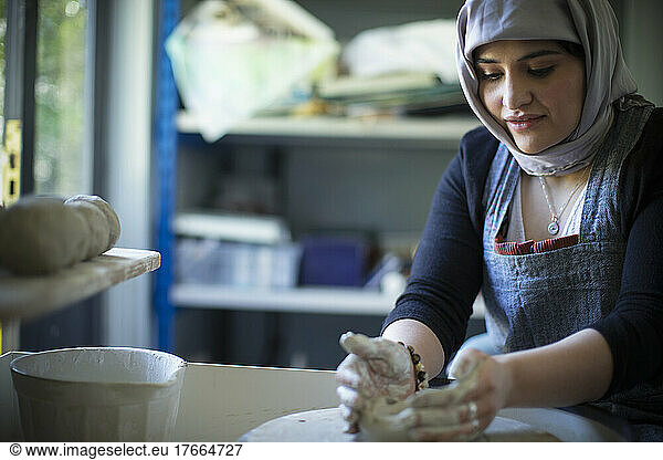 Junge muslimische Künstlerin an der Töpferscheibe im Kunstatelier