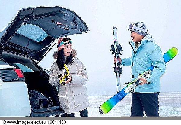 Junge Paare die Propeller-Köpfe  um die Skier auf den Kofferraum zu legen