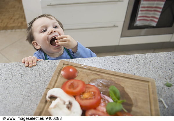 Junge - Person Küche Gemüse essen essend isst geschnitten