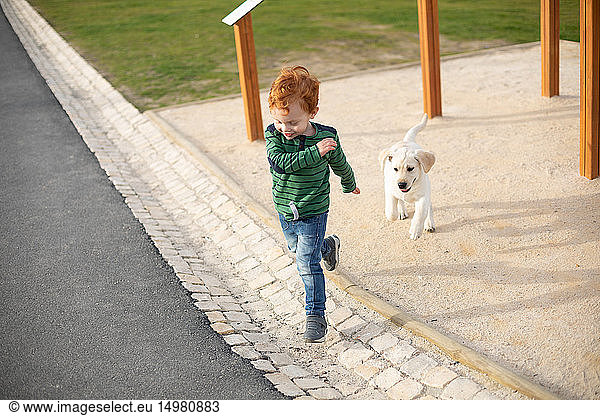 Junge rennt vor Haustier-Welpe weg