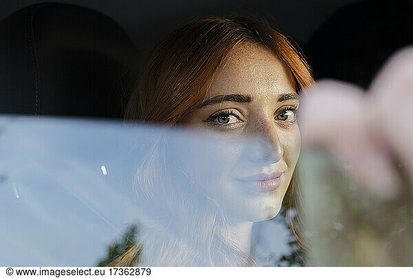 Junge rothaarige Frau starrt durch Autofenster gesehen