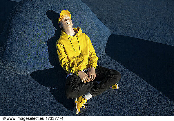 Junge ruht sich an einem sonnigen Tag im Skateboardpark aus