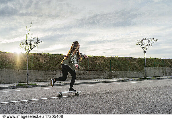 Junge Skaterin balanciert auf einem Skateboard