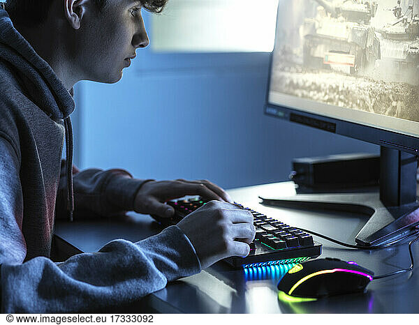Junge spielt Online-Spiel auf Computer am Tisch