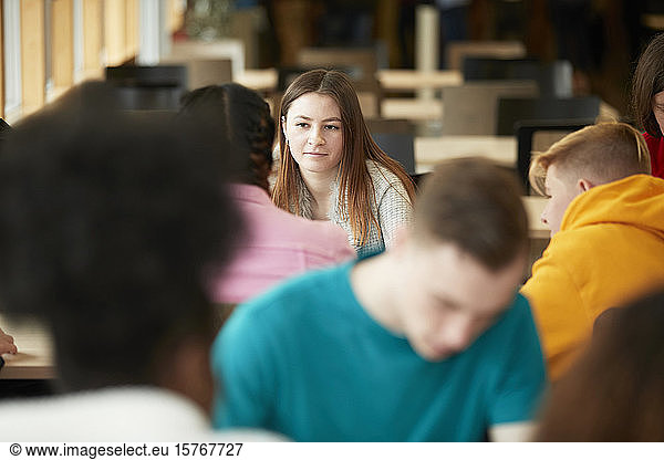 Junge Studentin hört einem Klassenkameraden zu