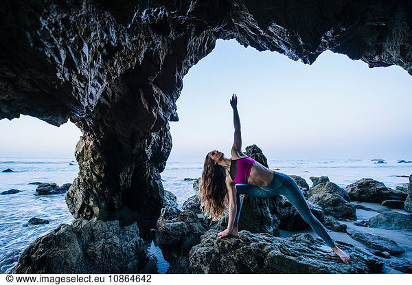 Junge Tänzerin balanciert balancierend auf der Hand in einer Meereshöhle  Los Angeles  Kalifornien  USA