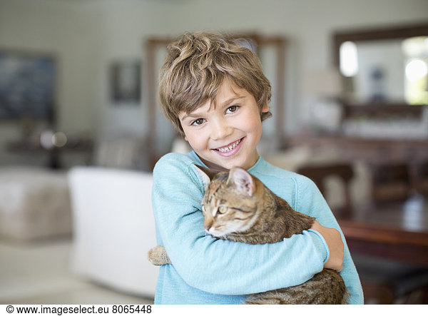 Junge umarmende Katze im Wohnzimmer