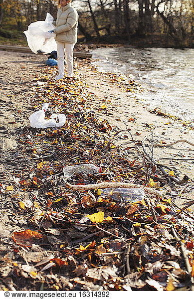 Junge Umweltschützerin sammelt Abfälle am See