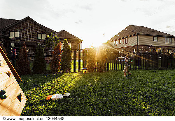 Junge wirft Ball beim Spielen im Hinterhof