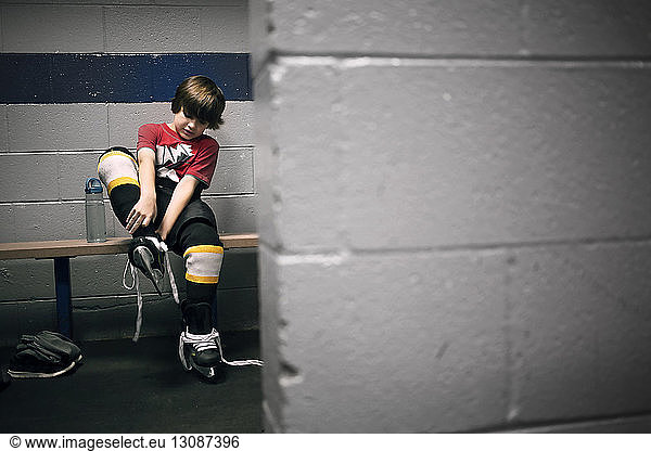 Junge zieht Eishockey-Schlittschuhe an
