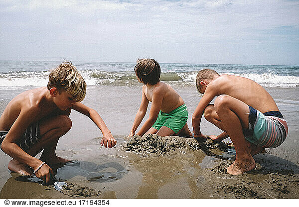 Jungen graben an einem sonnigen Sommertag im Sand