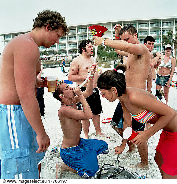 Jungen (Studenten)  die Bier durch einen Trichter am Strand trinken  Spring Break  Panama City  Florida  USA.