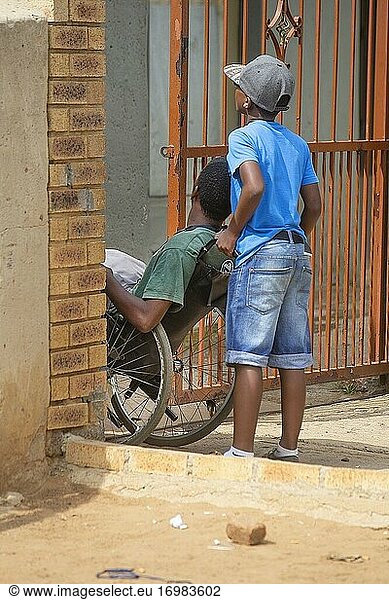 Junger afrikanischer Junge hilft behindertem Bruder in Soweto Township  Johanesburg  Südafrika