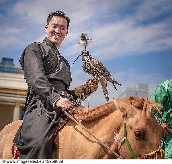 Junger Jäger mit ausgebildetem Falken auf dem Pferd  Stadt Ulaanbaatar  Mongolei  Asien