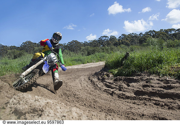 Junger männlicher Motocross-Fahrer rast durch die Schlammschleife