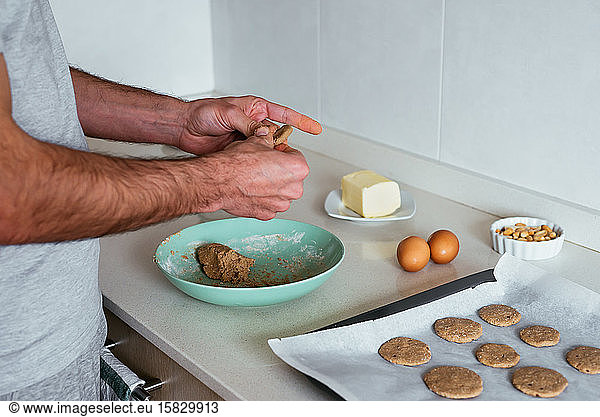 Junger Mann backt Kekse in der Küche