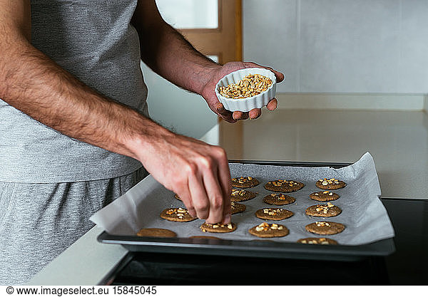 Junger Mann backt Kekse in der Küche