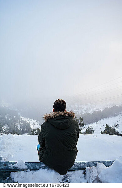 Junger Mann blickt an einem verschneiten Tag auf den Horizont
