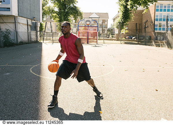 Junger Mann übt auf Basketballplatz