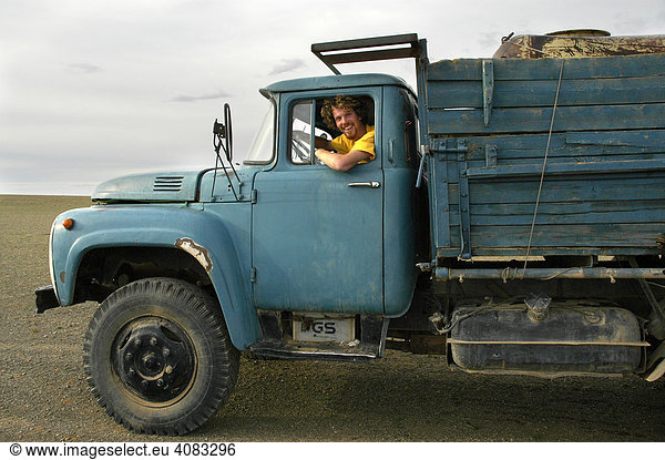 Junger Mann in Führerkabine eines alten russischen LKW Camp Tuvshin Mongolei