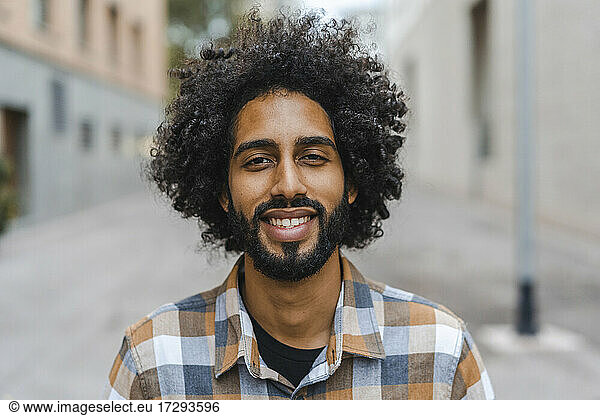 Junger Mann mit Afrofrisur lächelnd
