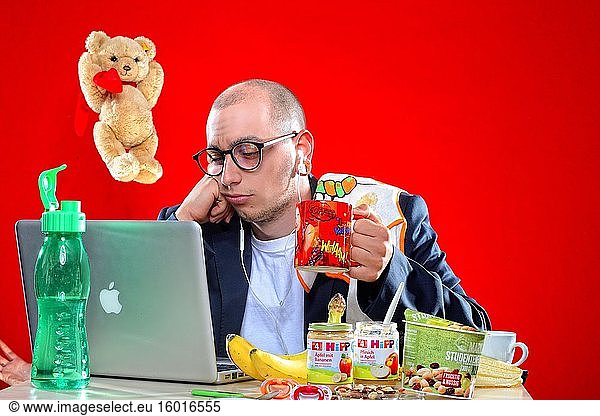 Junger Mann mit Snacks vor Laptop  Corona Serie  Deutschland  Europa