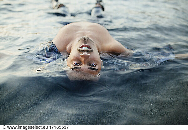 Junger Mann schwimmt im Wasser