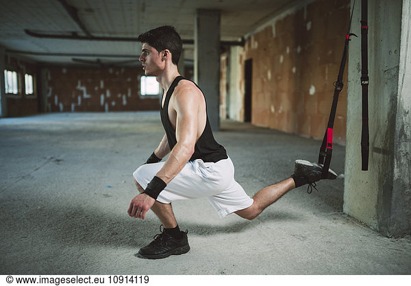 Junger Mann trainiert Fahrwerkstraining trx