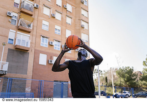 Junger Mann wirft Basketball