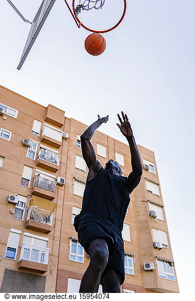 Junger Mann wirft Basketball