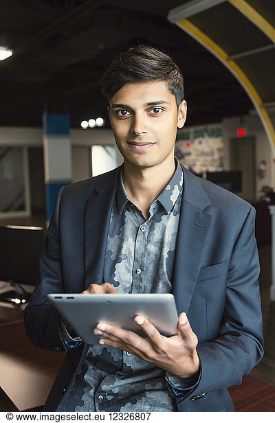 Junger Millennial-Geschäftsmann  der seine Technologie am Arbeitsplatz nutzt; Sherwood Park  Alberta  Kanada