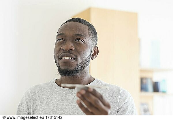 Junger schwarzer Mann hält eine Produkt Idee in der Hand  Vision  Innovation  Freiburg  Baden-Württemberg  Deutschland  Europa