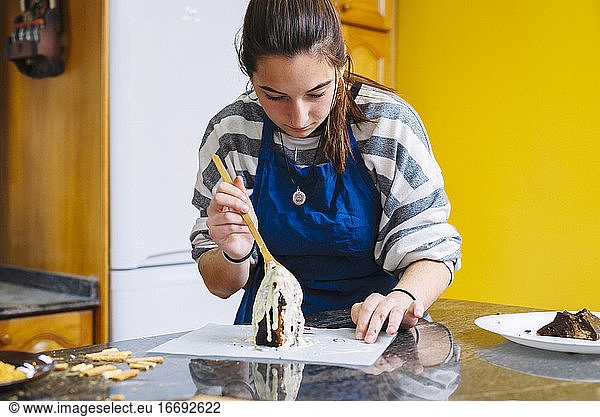 Junger Teenager backt Schokoladenkuchen in der Küche