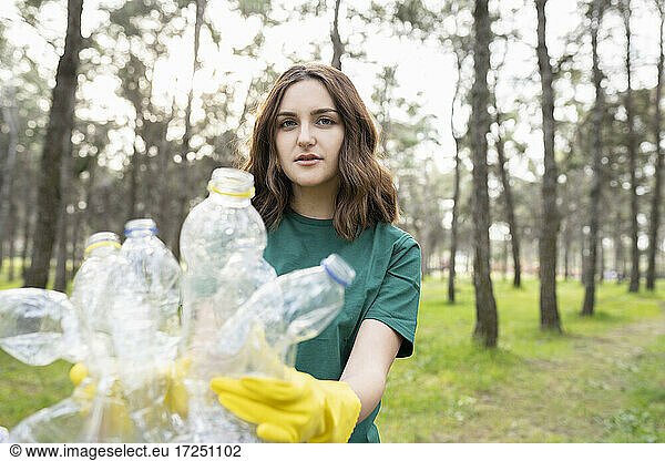 Junger Umweltschützer sammelt Plastikflaschen im Wald