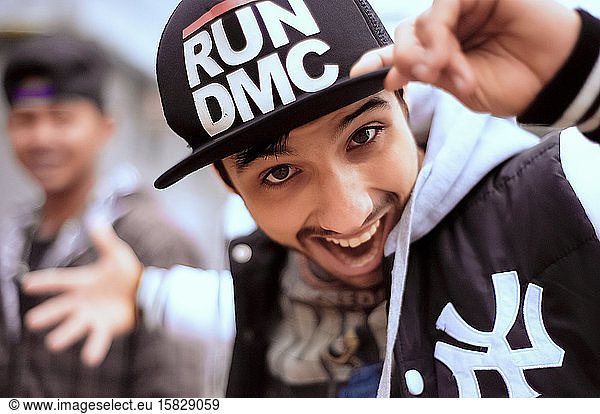 Junger verspielter Typ mit Hip-Hop-Mütze und Sportkleidung