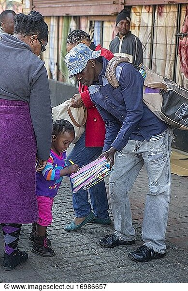 Junges afrikanisches Mädchen beim Schreiben mit zwei Erwachsenen in der Innenstadt von Johannesburg  Südafrika