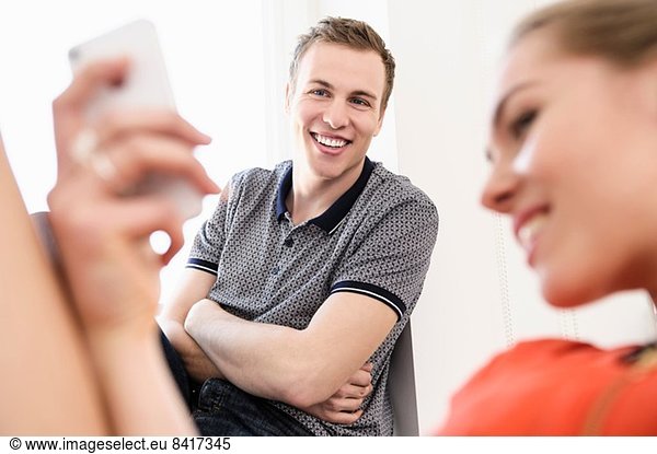 Junges erwachsenes Paar beim Blick aufs Handy