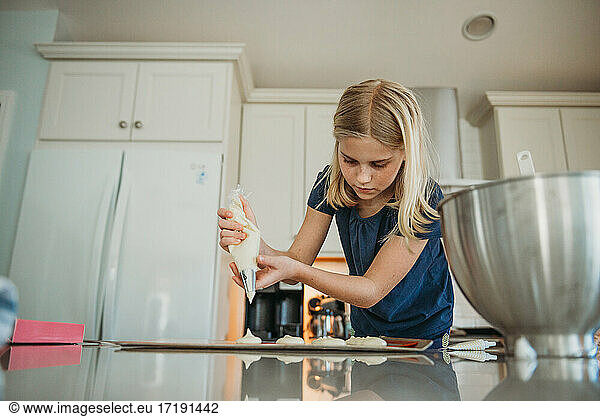 Junges Mädchen backt Macarons in der Küche