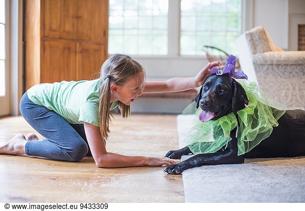 Junges Mädchen beim Verkleiden mit Haustier Hund