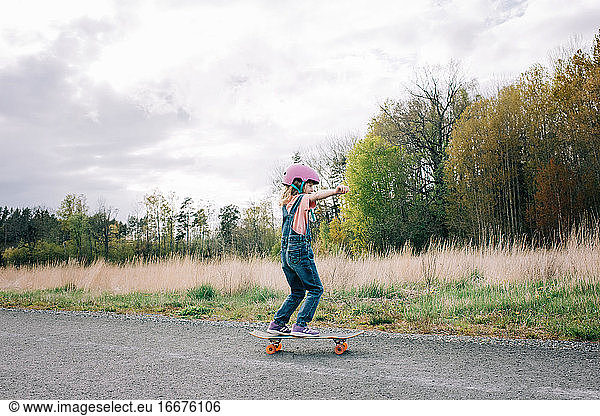 junges Mädchen lernt alleine Skateboard fahren