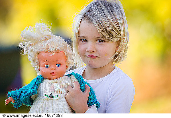 Junges Mädchen mit Oldtimer-Puppe