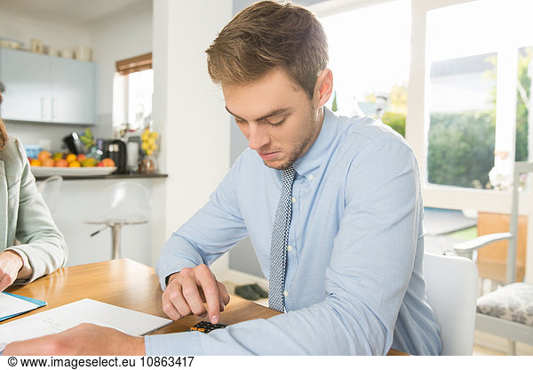 Junges Paar am Küchentisch beim Berechnen von Rechnungen und Finanzen