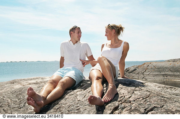 Junges Paar auf den Felsen sitzend