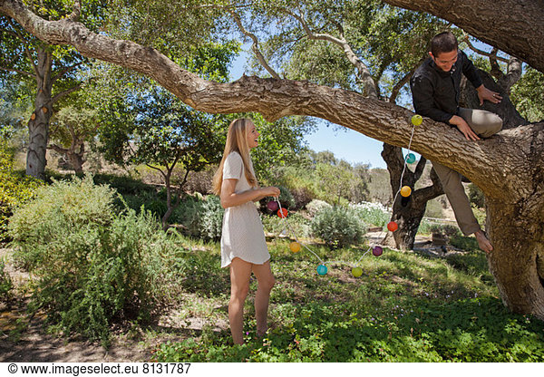 Junges Paar hängende Laternen im Baum