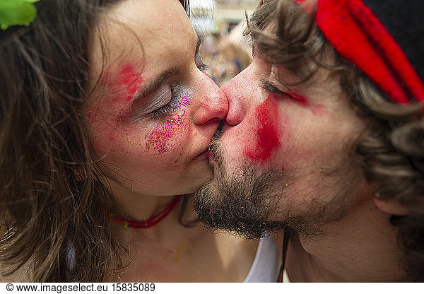 Junges Paar küsst sich leidenschaftlich auf dem Karneval