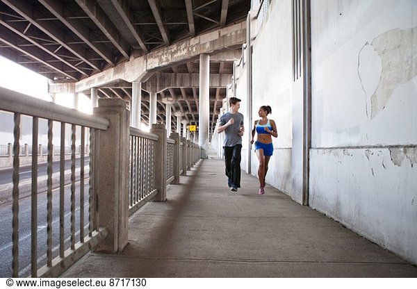 Junges Paar läuft auf der Stadtbrücke