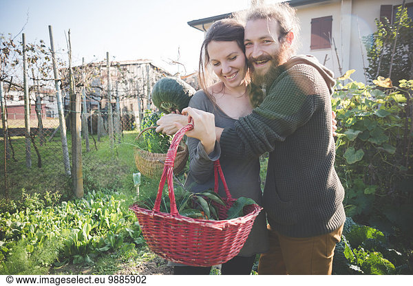 Junges Paar mit Gemüsekorb aus eigenem Anbau