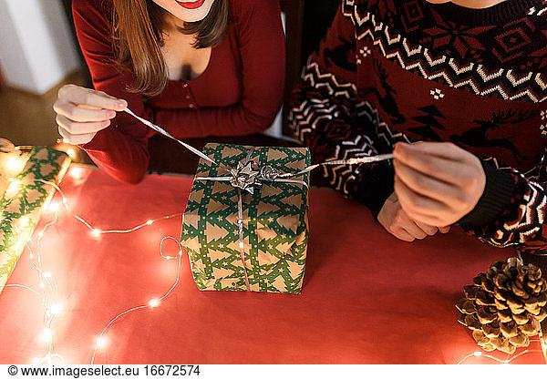 Junges verliebtes Paar mit Weihnachtsgeschenken in festlicher Atmosphäre