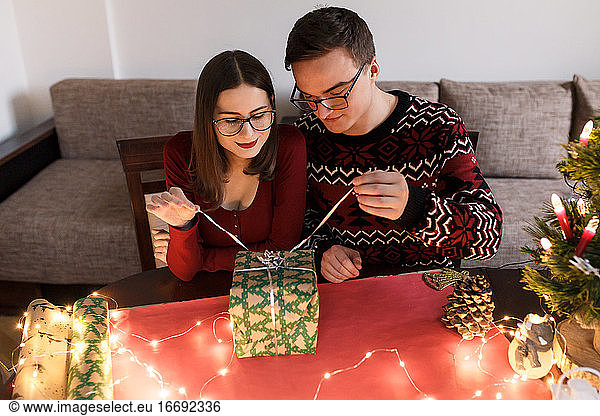Junges verliebtes Paar mit Weihnachtsgeschenken in festlicher Atmosphäre